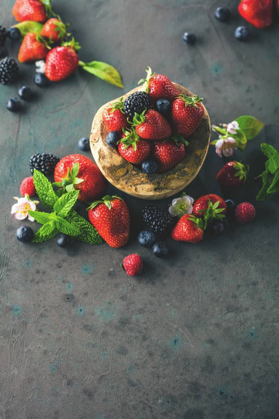 close-up view of fresh blackberries, blueberries, strawberries and green mint leaves - Foto, afbeelding