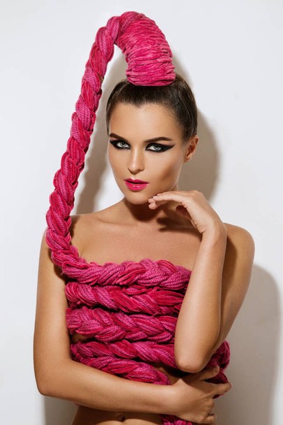 Young sexy woman with a long pink braid in her hair - Fotoğraf, Görsel