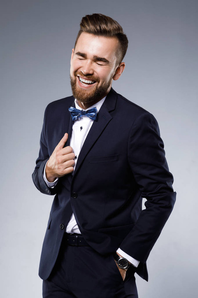 Stylish handsome man wearing a classic suit with bow-tie - Foto, Imagen