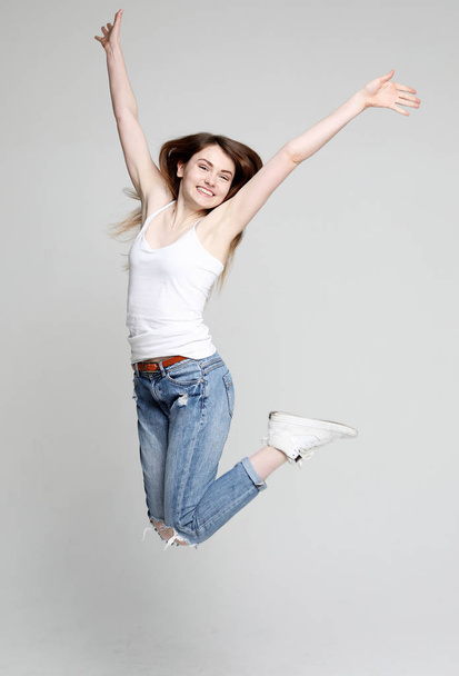 smiling young woman jumping in air over white  background  - Foto, imagen