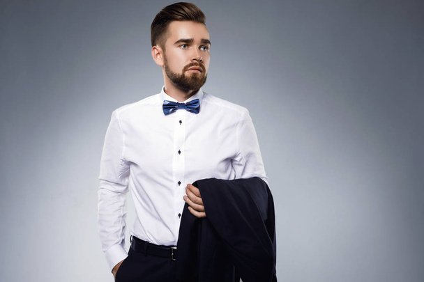 Stylish handsome man wearing a classic suit with bow-tie - Фото, изображение