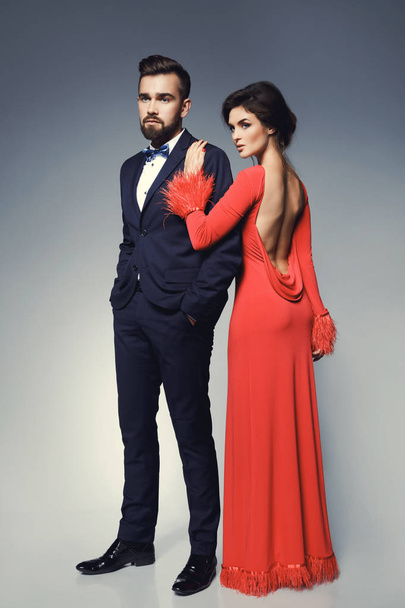 Woman in beautiful red dress and man wearing blue classical suit - Foto, afbeelding
