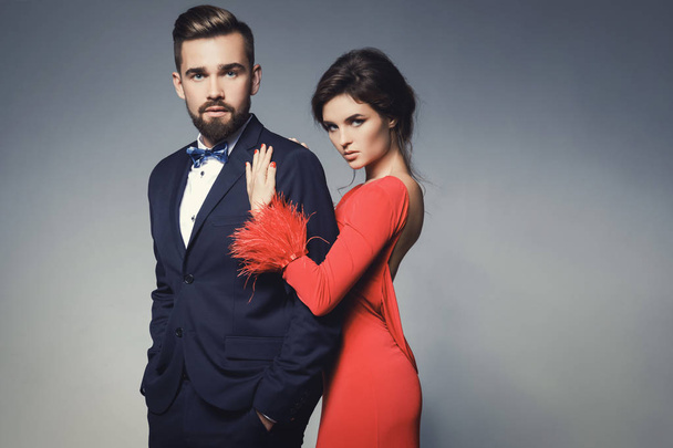 Жінка в красивій червоній сукні і чоловік в синьому класичному костюмі
 - Фото, зображення