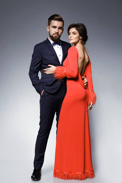 Woman in beautiful red dress and man wearing blue classical suit - Foto, Imagen