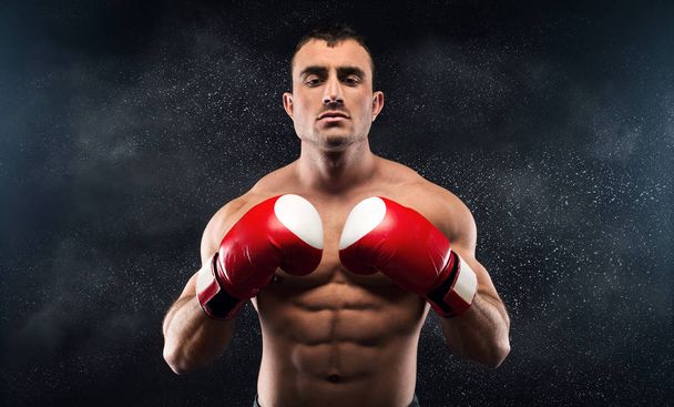 Sporty young man showing his hands in red gloves - Photo, Image