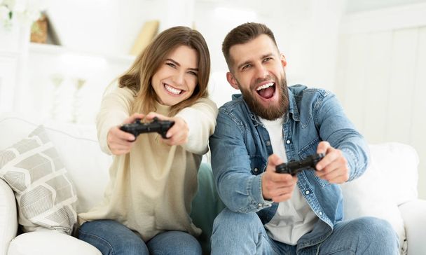 Rindo casal jogando videogames por Joysticks
 - Foto, Imagem