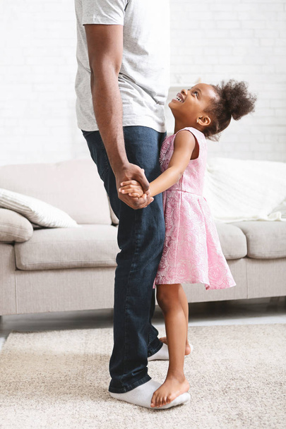Pieni afrikkalainen amerikkalainen tyttö tanssimassa isän kanssa
 - Valokuva, kuva