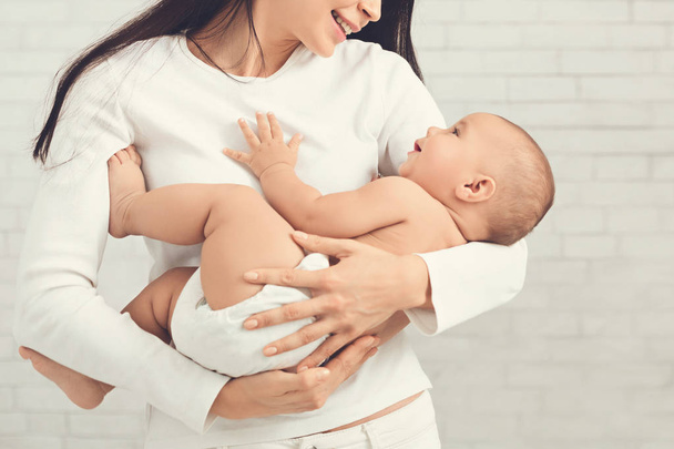 Jovem mãe abraçando seu filho recém-nascido bonito
 - Foto, Imagem
