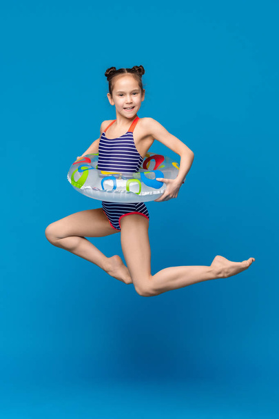 Маленькая девочка в купальнике прыгает с надувным кольцом
 - Фото, изображение