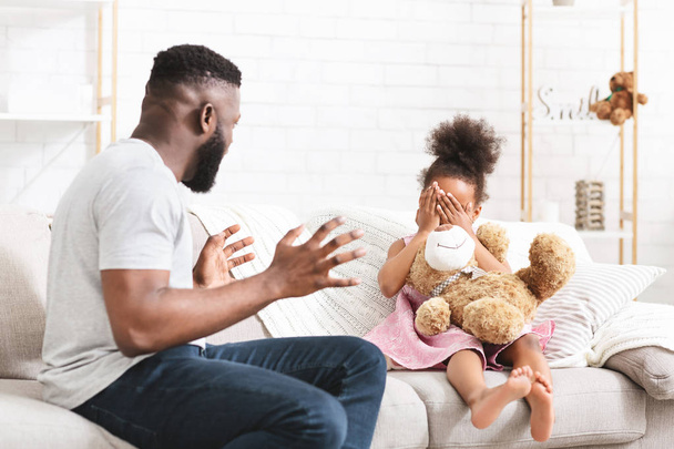 Enojado afroamericano padre gritando a su pequeña hija
 - Foto, imagen