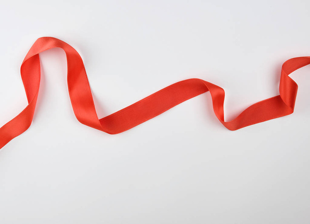 curled red satin ribbon on a white background - Zdjęcie, obraz