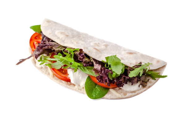 The concept of Italian cuisine. Vegatarian piadina with tomatoes, mozzarella cheese, mix lettuce, arugula and sauce on a white background. Isolate - Photo, image