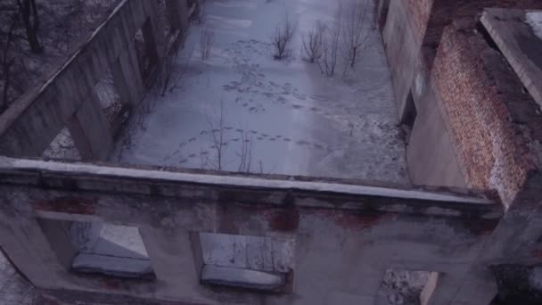 Lot nad opuszczonym budynkiem, stary zniszczony budynek w sezonie zimowym. Widok z lotu ptaka 4K - Materiał filmowy, wideo