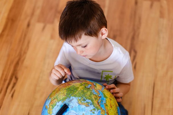 five-year-old looking for a city on a large globe - Фото, зображення