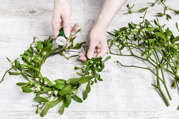 Florist at work: how to make mistletoe door wreath tutorial. - Photo, image