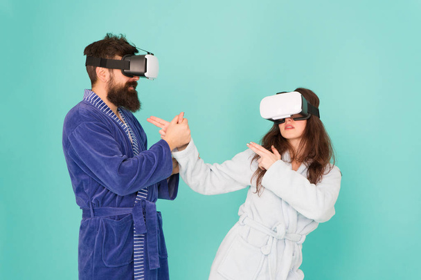 Future is closer than you think. VR technology and future. VR communication. Exciting impressions. Couple in bathrobes wear VR glasses. Gaming and entertainment. Man and woman explore VR at home - Fotoğraf, Görsel