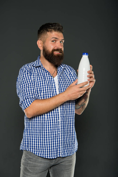 Health care and diet. Milk products. Consuming lactose. Healthy nutrition. Yogurt probiotics and prebiotics. Bearded man hold white bottle with milk. Brutal caucasian hipster drink milk. Lactose diet - Foto, afbeelding