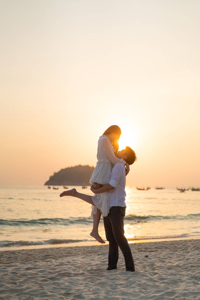 Happy couple going honeymoon travel on tropical sand beach in su - Photo, Image