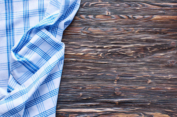 Old dark wooden background. Wooden table with blue kitchen towels - Foto, Bild