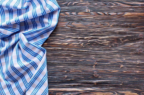 Old dark wooden background. Wooden table with blue kitchen towels - Foto, Imagem