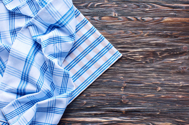 Old dark wooden background. Wooden table with blue and white kitchen towel - Foto, Imagem
