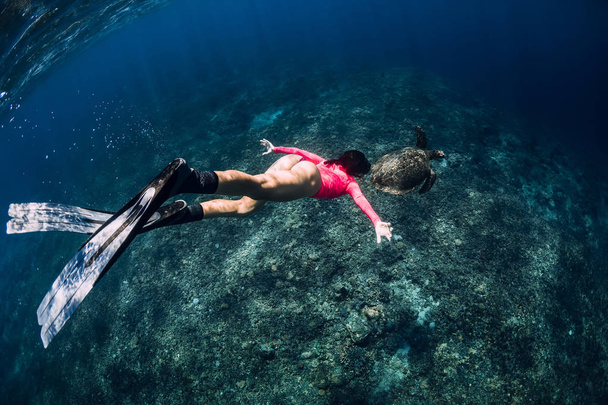 Jovem freediver com barbatanas nadar debaixo d 'água com tartaruga marinha
. - Foto, Imagem