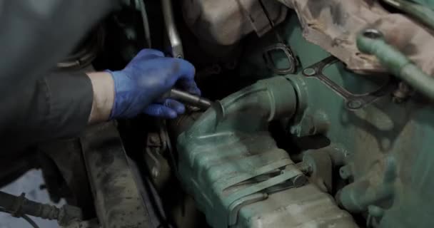 Car truck repair. The mechanic twists the part against the background of the engine the car or truck - Filmmaterial, Video