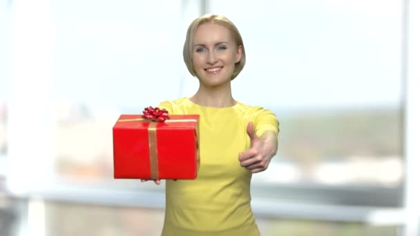 Veselá žena dávat dárkovou krabici a palec nahoru. - Záběry, video