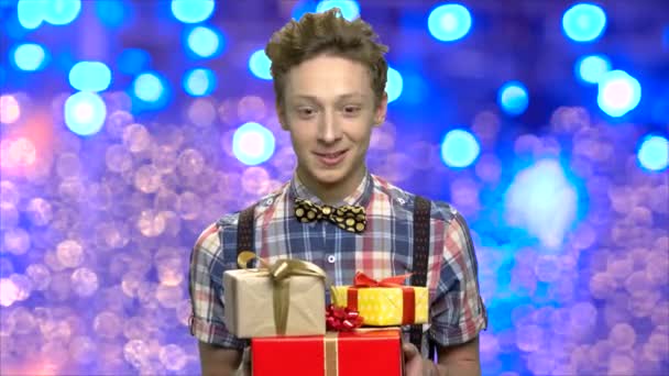 Ekspresyjny nastoletni chłopiec z pudełka na prezenty świąteczne. - Materiał filmowy, wideo