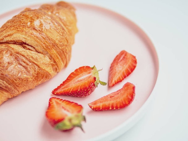 Desayuno de verano. Placa rosada con croissants y fresa. Primer plano
 - Foto, imagen