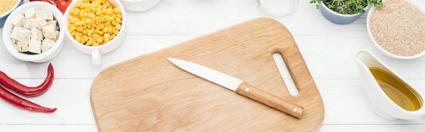 top view of wooden chopping board with knife on white table, panoramic shot - Photo, Image