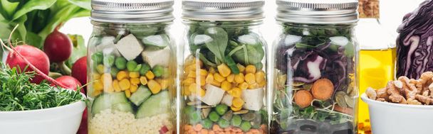 délicieuse salade de légumes frais dans des bocaux en verre sur table blanche en bois isolé sur blanc, vue panoramique
 - Photo, image