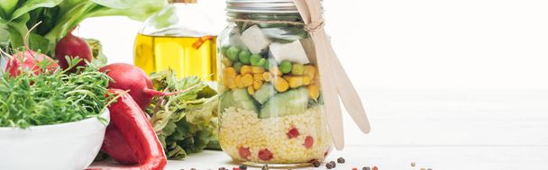 salade de légumes frais dans un bocal en verre avec couverts en bois isolé sur fond blanc, panoramique
 - Photo, image