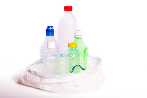 Muovisaaste. Tyhjiä muovipulloja valkoisessa jätesäkissä, eristetty valkoisella pohjalla
 - Valokuva, kuva