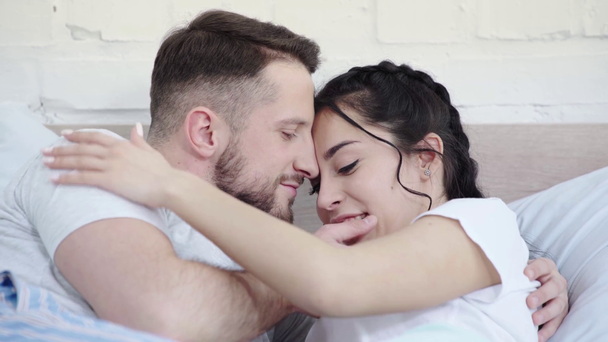 rack középpontjában boldog ember megható arca, megcsókolta az orr és a kezét a vonzó nő, miközben feküdt az ágyon  - Felvétel, videó