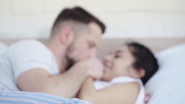 szelektív középpontjában boldog ember csók az orr és a kezét a vonzó nő, miközben feküdt az ágyon  - Felvétel, videó