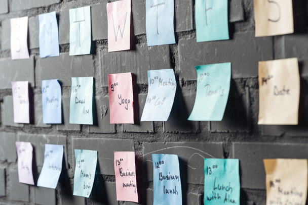 siyah tuğla duvara renkli renkli etiket notları seçici odak - Fotoğraf, Görsel