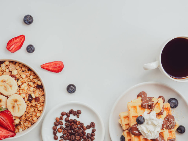 Breakfast berries and oatmeal frame with copy space. Waffle with fruits, chocolate and whipped cream. Flat lay - Photo, Image