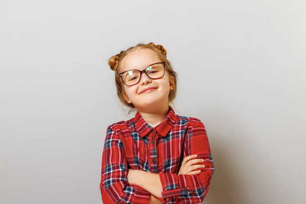 Portrait of a funny little preschool child girl in glasses on gray background. Concept education. Back to school. - Foto, Bild