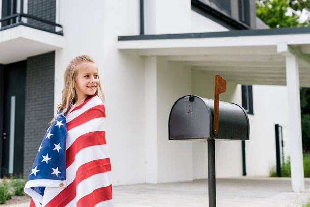 garoto feliz de pé com bandeira americana perto da caixa de correio
 - Foto, Imagem
