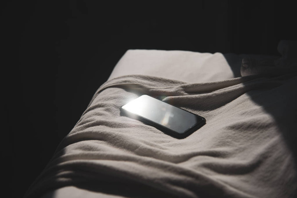 Smartphone place on the bed in bedroom at hotel in selective foc - Foto, Imagen