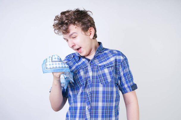 Alergia Boy Child com corrimento nasal segurando um lenço. Adolescente está tendo má saúde e de pé no fundo do estúdio branco sozinho
. - Foto, Imagem