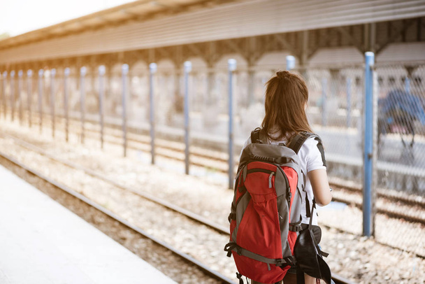トライで列車を待っているアジアの若い女性観光客のバックビュー - 写真・画像