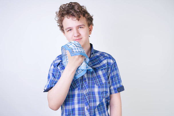 Niño alérgico con secreción nasal sosteniendo un pañuelo. Adolescente está teniendo mala salud y de pie en el fondo del estudio blanco solo
. - Foto, imagen