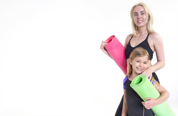 Мати і дочка тримають килимки для йоги, ізольовані на білому
 - Фото, зображення