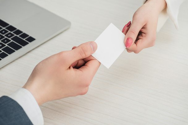 cropped view of businessman and businesswoman holding white empty business card, panoramic shot - Foto, imagen