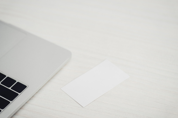 white empty business card near laptop on wooden office table - Fotoğraf, Görsel