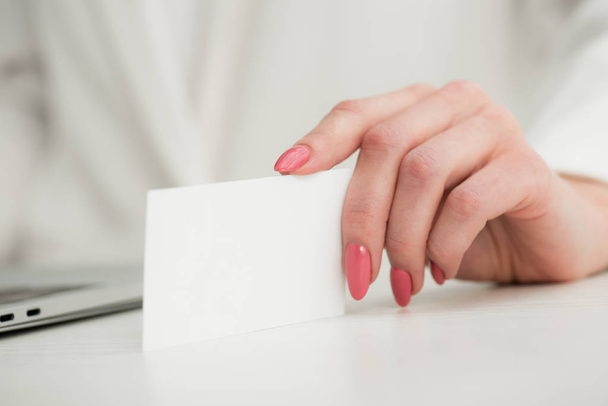 partial view of businesswoman holding white empty business card - Foto, imagen