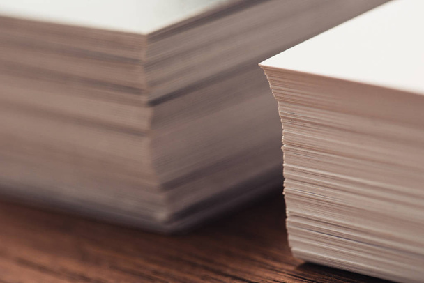 selective focus of stacked business cards on brown wooden surface  - 写真・画像
