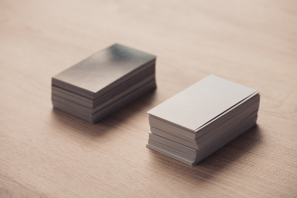 stacks of black and white empty business cards on wooden surface - Foto, afbeelding